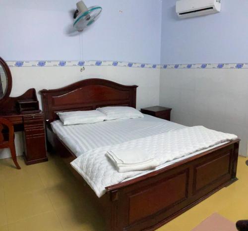 a bedroom with a bed and a dresser and a fan at Phúc Lộc Thọ Hotel in Ho Chi Minh City
