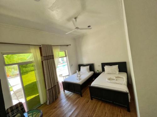 a room with two beds and a window at Sunrise Villas in Jambiani