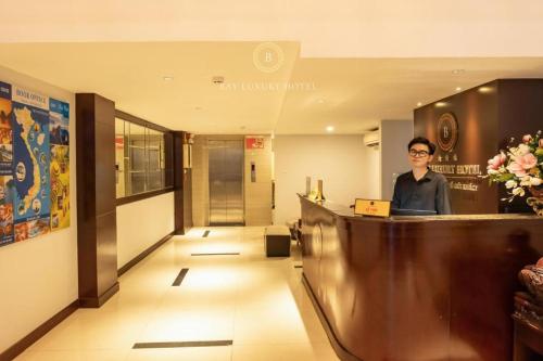 a man standing at a counter in a hotel lobby at Hotel No 9 Nguyễn Trường Tộ - by Bay Luxury in Hanoi