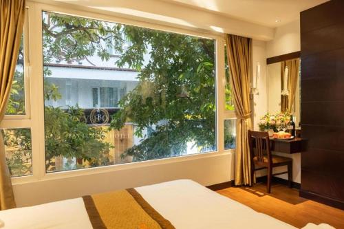 a bedroom with a large window and a desk and a bed at Hotel No 9 Nguyễn Trường Tộ - by Bay Luxury in Hanoi