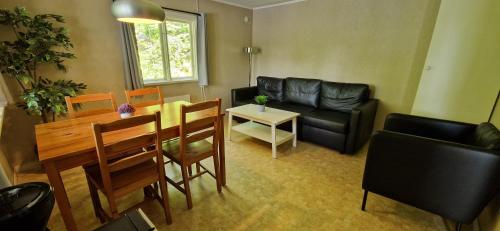 a living room with a black couch and a table at Långasjönäs Camping & Stugby in Karlshamn