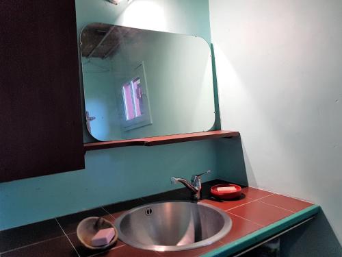 une salle de bain avec un lavabo et un miroir dans l'établissement Maison Rouge, à Varengeville-sur-Mer