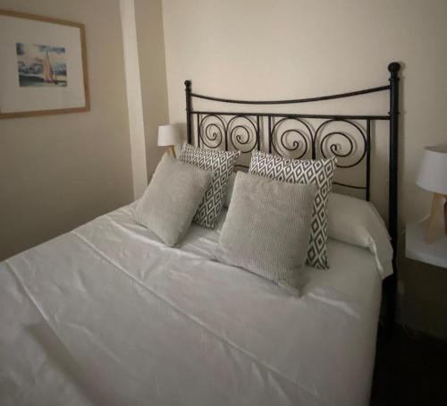 a bedroom with a white bed with pillows at Apartamento Plaza Grande in Zafra