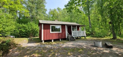 a red tiny house in the middle of a forest at Långasjönäs Camping & Stugby in Karlshamn