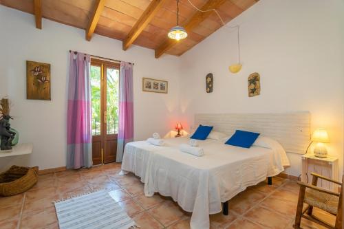 a bedroom with a large white bed with blue pillows at Es Garballons in Manacor