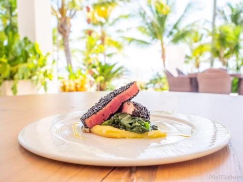 eine weiße Platte mit einem Stück Essen auf dem Tisch in der Unterkunft Tracadero Beach Resort in Bayahibe