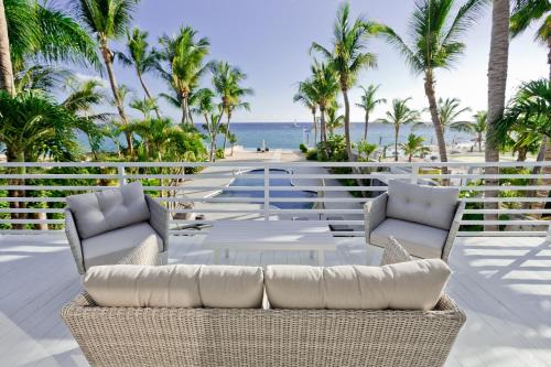 a patio with chairs and a table and the ocean at TRACADERO Beach Club & Holidays Rentals in Bayahibe