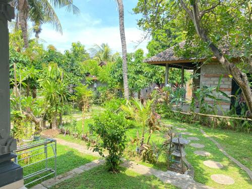 a garden with a bench and a house at Suris bungalows in Pabean Buleleng