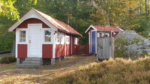 a small red and white building with a gate at Långasjönäs Camping & Stugby in Karlshamn