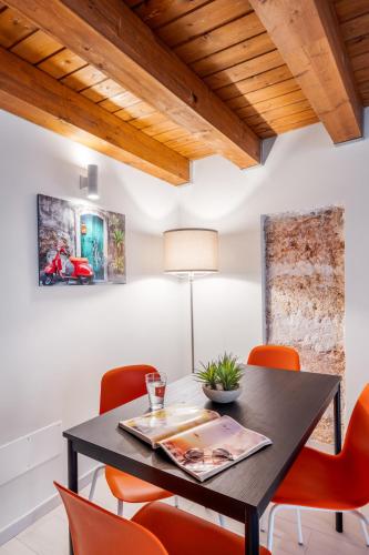 a dining room with a black table and orange chairs at Open Sicily Homes - Near the Central Train Station in Palermo