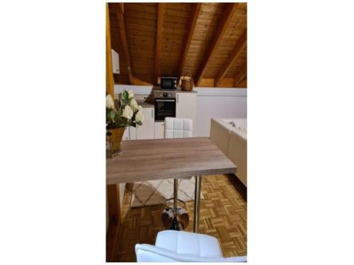 cocina con mesa de madera y sillas blancas en Ferienwohnung Frank 50 qm, en Bad Emstal