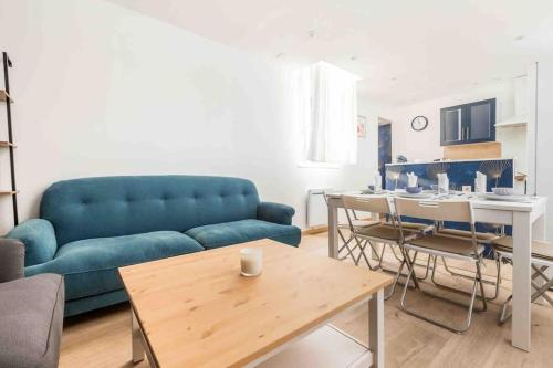 un salon avec un canapé bleu et une table dans l'établissement Maison spacieuse proche Lille, à Roubaix