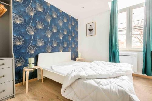 - une chambre avec un lit et un mur bleu dans l'établissement Maison spacieuse proche Lille, à Roubaix