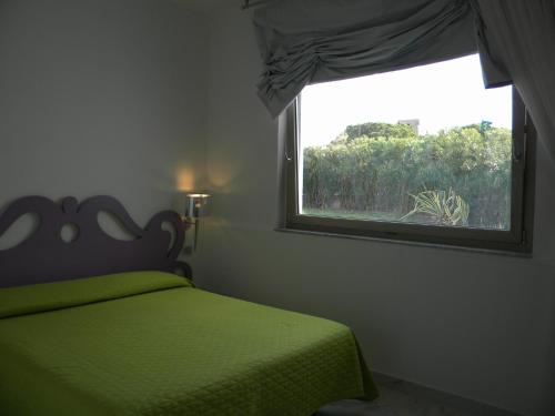 a bedroom with a green bed and a window at HOTEL GENOVA in Scalea