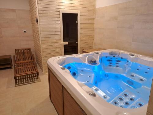 a bathroom with a large tub with a blue tub at Penzión pri studničke Omastiná in Omastiná