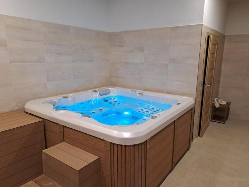 a jacuzzi tub with a blue inside of it at Penzión pri studničke Omastiná in Omastiná