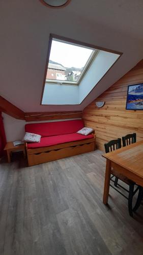 a attic room with a bed and a window at Appartement 42M² pour 4/6 personnes à VALMEINIER 1800 in Valmeinier