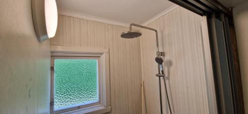 a shower in a bathroom with a window at Långasjönäs Camping & Stugby in Karlshamn