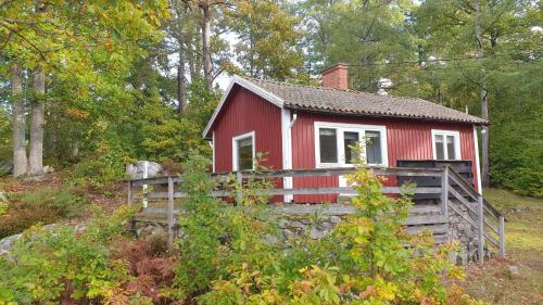 a red house on a hill in the woods at Långasjönäs Camping & Stugby in Karlshamn