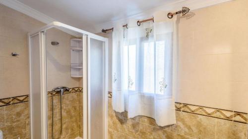 a shower curtain in a bathroom with a window at Casa Herrero El Borge by Ruralidays in Almáchar