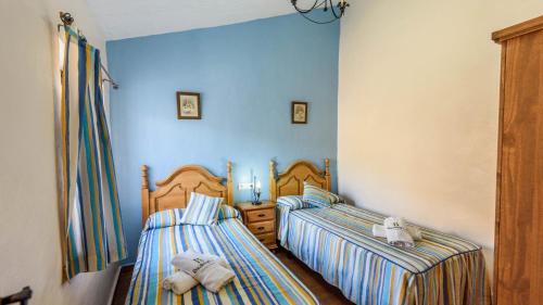 two twin beds in a room with blue walls at Casa Herrero El Borge by Ruralidays in Almáchar