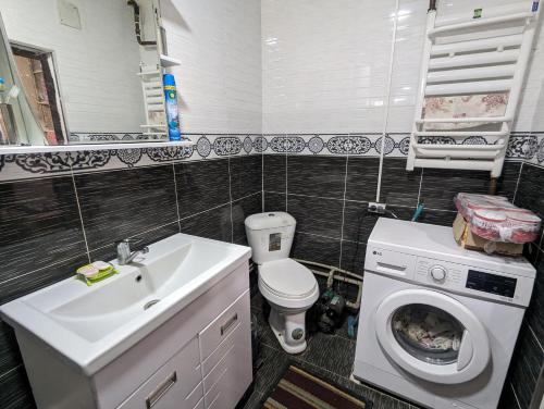 a bathroom with a toilet and a sink and a washing machine at Guest house Muslim 