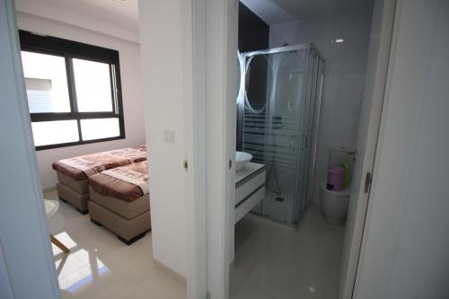 a bathroom with a bed and a shower and a sink at COSTA ELISA20 MIL PALMERAS in La Horadada