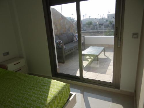 Cette chambre comprend un lit et une fenêtre avec un canapé. dans l'établissement Villa Sinergia 3 bedrooms, à Los Alcázares