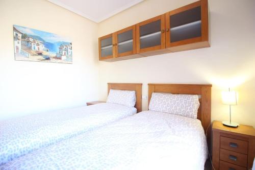 two beds in a bedroom with white sheets at Family Townhouse 6 sleeps Maribel in Rojales