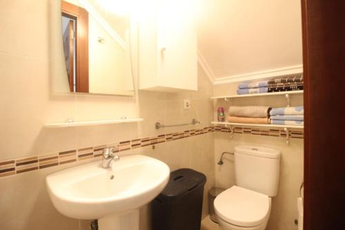 a white bathroom with a sink and a toilet at Family Townhouse 6 sleeps Maribel in Rojales