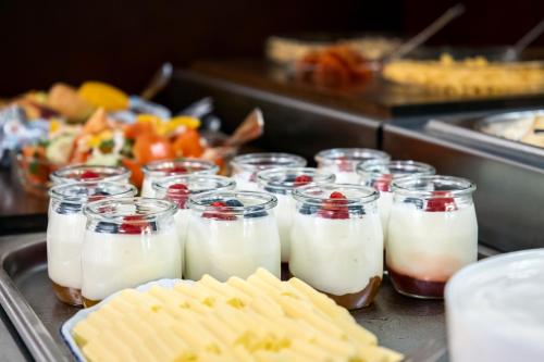 a group of glasses of milk and waffles on a buffet at Hotel Orion in Prague