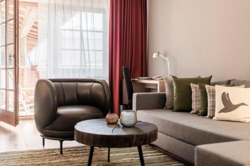 a living room with a couch and a chair and a table at Das Achental Resort in Grassau