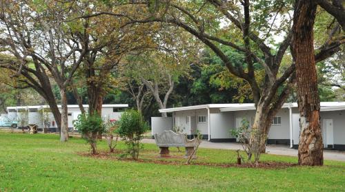 a park with a bench in front of a building at Cresta Sprayview Victoria Falls in Victoria Falls