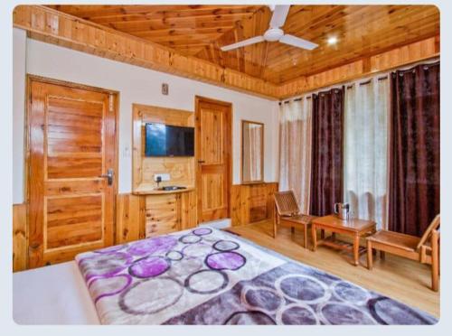 1 dormitorio con 1 cama grande y techo de madera en Hotel Sun Mark en Manāli