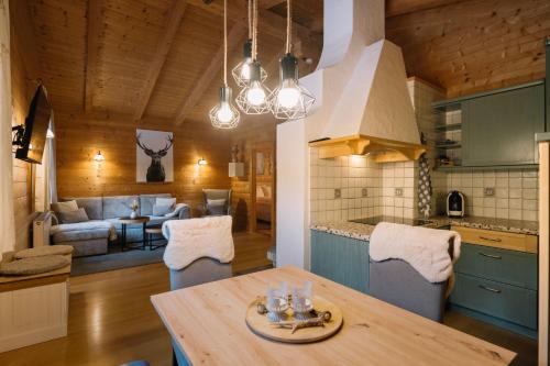 eine Küche und ein Wohnzimmer mit einem Tisch und einem Sofa in der Unterkunft Steinnock Chalet in Bad Kleinkirchheim