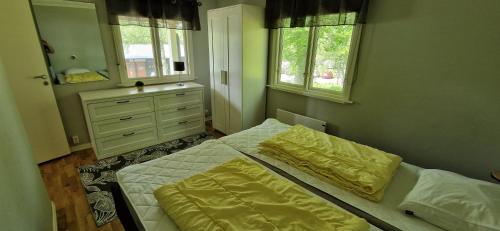 two beds in a bedroom with two windows at Långasjönäs Camping & Stugby in Karlshamn