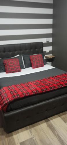 a black bed with two red pillows on it at B&B Be happy in Taranto