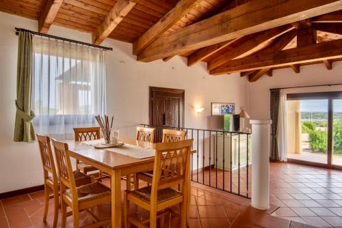 a dining room with a wooden table and chairs at Villas with air conditioning and shared pool, just a few minutes from La Pelosa beach in Cuile Pazzoni