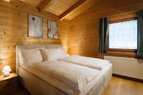 ein Schlafzimmer mit einem Bett in einem Holzzimmer in der Unterkunft Steinnock Chalet in Bad Kleinkirchheim