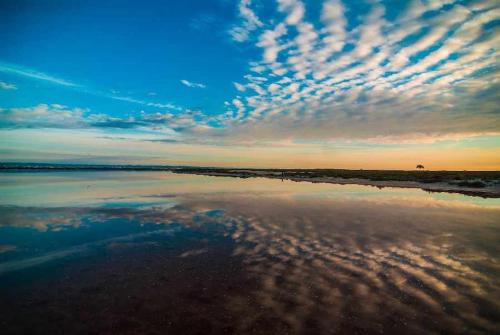 a sunset on the beach with clouds in the sky at Apartamento Lopagan Entremares in Lo Pagán