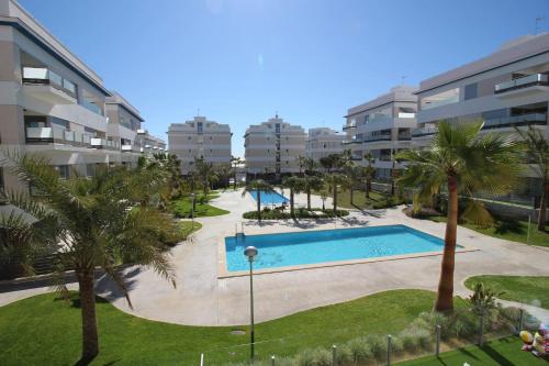 un complejo de apartamentos con piscina y palmeras en Los Dolses Mirador Apartments 2 beds, en 