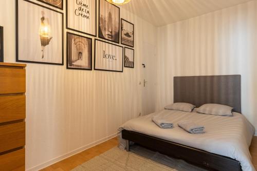 Cama en habitación con cuadros en la pared en SmartStay coeur de Vienne, en Vienne