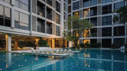 a swimming pool in front of a building at Cozy Room in Bangkok, BTS Onnut (E9) Station in Bangkok