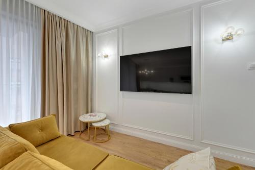 a living room with a couch and a flat screen tv at GRANO APARTMENTS Gdańsk Old Town SPA & Wellness - GRANO APARTMENTS Gdańsk Residence SPA & Wellness in Gdańsk