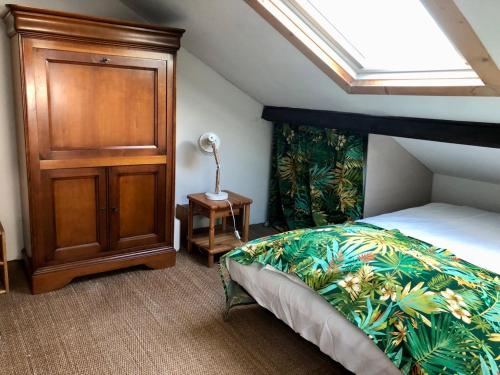 1 dormitorio con 1 cama y armario de madera en Charmante maison à Jard sur mer sur la côte vendéenne, en Jard-sur-Mer
