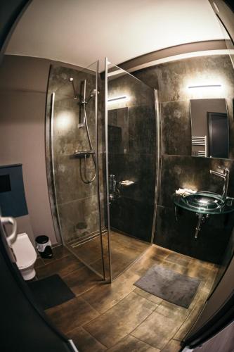a bathroom with a glass shower and a sink at Ride More Activity Center in Miercurea-Ciuc