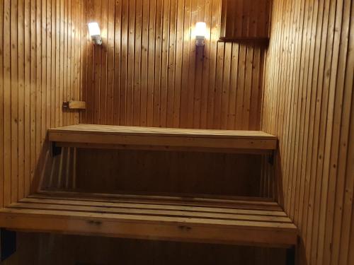 a wooden bench in a room with two lights at Långasjönäs Camping & Stugby in Karlshamn
