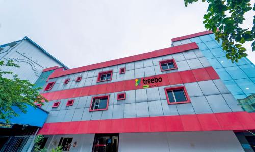 un edificio rojo y blanco con un cartel en él en Treebo Trend NGH Transit en Chennai