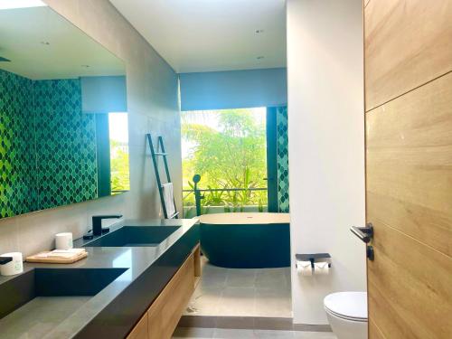 a bathroom with a blue sink and a tub at Moon Villa Phu Quoc - 3 Bedroom - Private pool in Phú Quốc