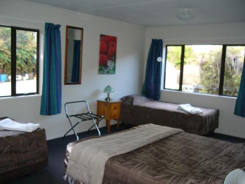 a hotel room with two beds and a chair at Central & Relaxing in Franz Josef